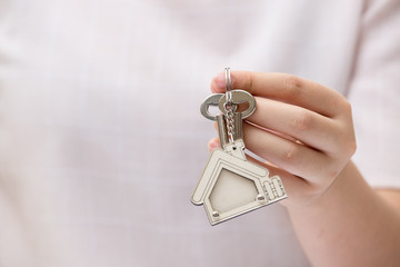 Fototapeta premium Woman hand holding home key. Concept for real estate business.