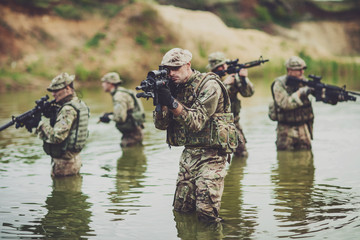 special forces soldiers with weapon take part in military maneuver. war, army, technology and...