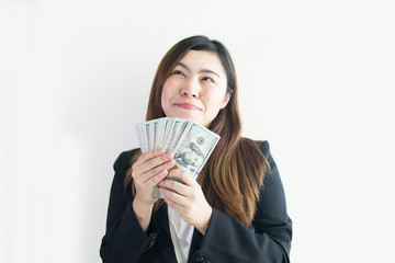 Asian business woman is enjoy with big money US Dollar notes on white background isolated.