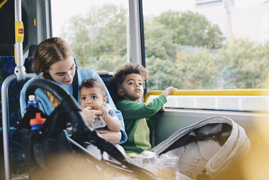 Mother sitting with sons in bus
