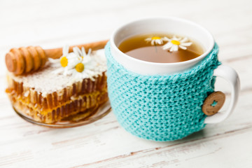 Honeycomb and chamomile tea on white