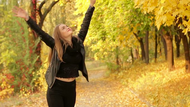 young beautiful woman enjoying the beauty of autumn park