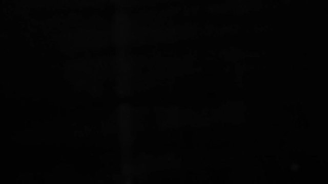 The concept of hand holding a large knife blade upwards diagonally on black background.
