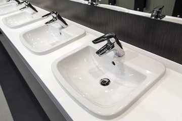 Clean public restroom sinks in a dramatic angle