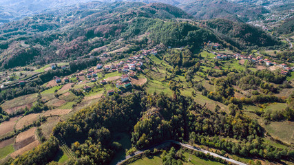 Fototapeta na wymiar Aerial Shot Of A Small Village Into The Mountain At Autumn