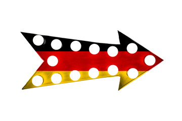 Flag of Germany painted over vintage bright and colorful illuminated metallic display arrow sign with light bulbs against a seamless white background