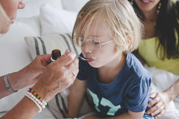 Grandmother giving boy medicine
