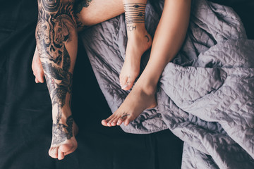 tattooed couple in bed