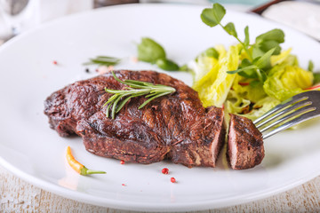 Delicious Striploin steak and salad are on the plate