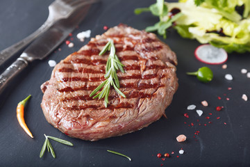 Juicy rib-eye on a stone table..