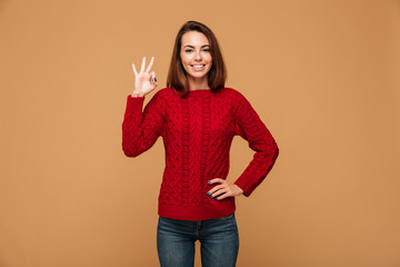 Caucasian lady with okay gesture dressed in sweater