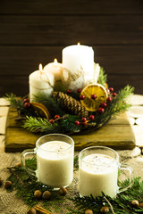 hot milk alcoholic drink   Egg-nog next to the Christmas candle and candles