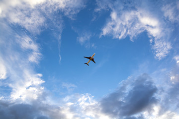 Fototapeta na wymiar Airplane flying on blue sky. Business travel.