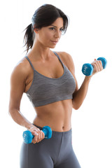 Beautiful young woman lifting dumbbells at home.