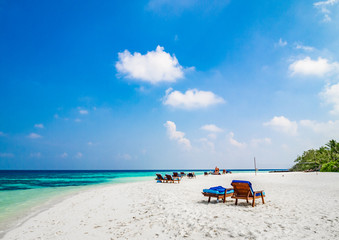 Tropical island vacation image, white sand beach and sun beds