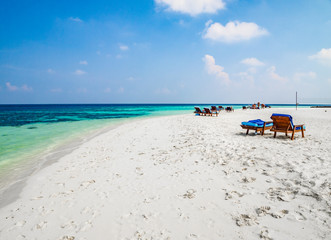 Tropical island vacation image, white sand beach and sun beds