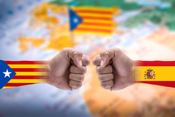 The double exposure image of the isolated arm overlay with Catalonia and Spanish flag and the blurred Catalonia flag image is backdrop. The concept of protesting, and Declaration of independence.