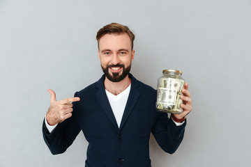 happy confident man pointing at box with money isolated