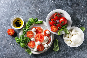Italian caprese salad with sliced tomatoes, mozzarella cheese, basil, olive oil. Served in ceramic...