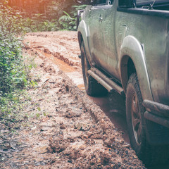 Closeup offroad car at the impassable forest road of mud and clay. offroad travel concept.