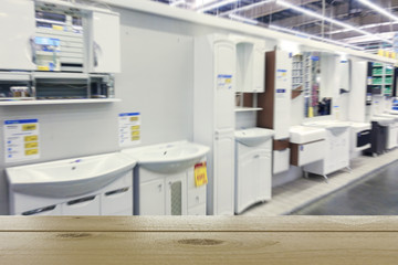 Bathroom furniture store. Defocused image. In the foreground is the top of a wooden table or counter.