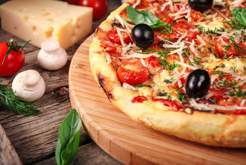 Fresh pizza with tomatoes, cheese and mushrooms on wooden table closeup