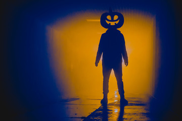Silhouette standing man with halloween head in the darkness
