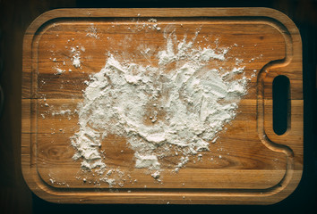White flour on a wooden cooking desk.