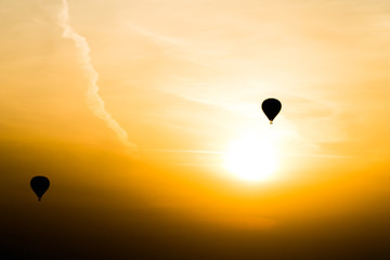 Two air baloons flying against the purple sunset during summer