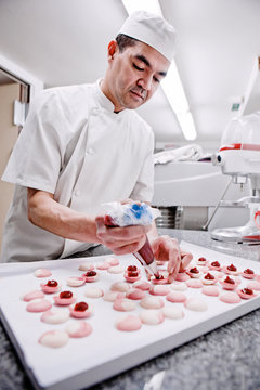 p&acirc;tissier pr&eacute;pare des macarons