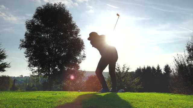 Golf Player plays golf on a beautiful summer morning. Lens flare Back lite shot 
