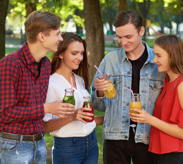 Group of happy young people enjoys detox cocktails and spend time together at summer. Friendship, youth lifestyle, vegetarian diet, fitness food on the go, successful weight loss concept