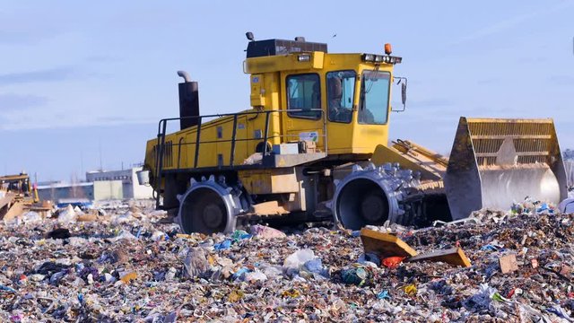 A landfill compactor working at landfill. Waste, garbage, dump, rubbish 4K.
