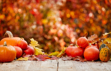 pumpkins on a table with autumn leaves
