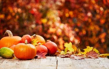 pumpkins on a table with autumn leaves