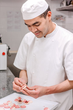 p&acirc;tissier pr&eacute;pare des macarons
