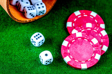 poker chips and dice on green background top view