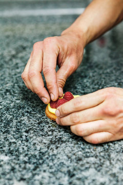 p&acirc;tissier pr&eacute;pare une tartelette framboise
