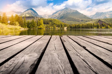 Majestic mountain lake in National Park High Tatra. Wooden table place of free space.