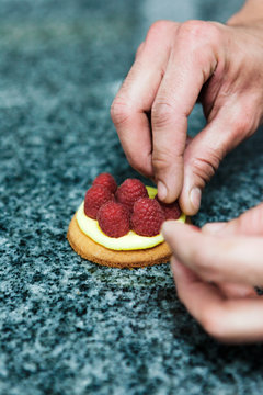 p&acirc;tissier pr&eacute;pare une tartelette framboise