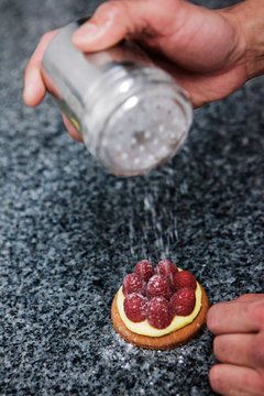 p&acirc;tissier pr&eacute;pare une tartelette framboise