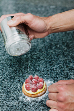p&acirc;tissier pr&eacute;pare une tartelette framboise