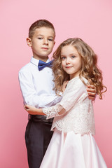 Boy and girl standing in studio on pink background