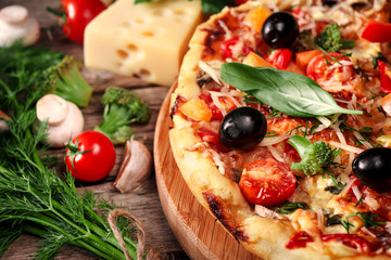 Fresh pizza with tomatoes, cheese and mushrooms on wooden table closeup
