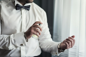 Handsome guy is choosing perfumes,Rich man prefers expensive cologne,Elegant man in suit using cologne or perfume,Male perfume,Successful businessman likes perfume scent