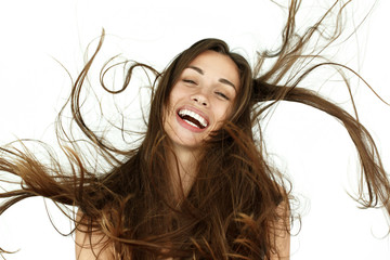 Beautiful woman shakes her hair on white background