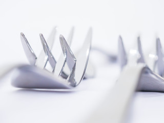 Closeup of matching forks on the white table.