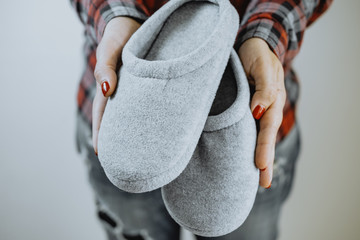 Female hands hold cozy slippers