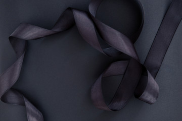 Black ribbon on black background. Creative frame for advertising, blogging campaign with copy space for text
