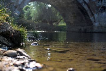 Fototapeta na wymiar a low shot of a river going under a bridge